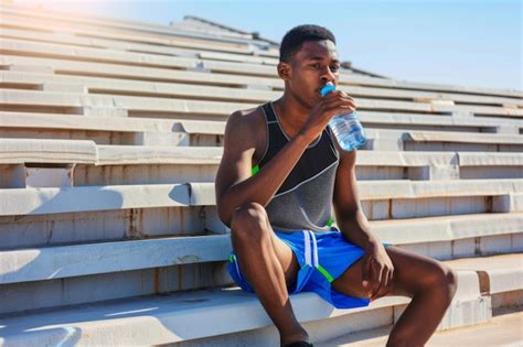 Premium Photo | Athlete resting and hydrating during outdoor workout