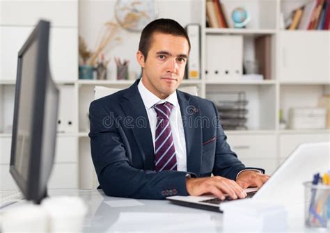 Focused Office Employee Working with Laptop and Documents Stock Photo ...