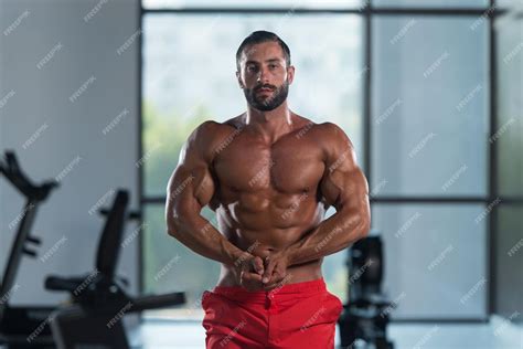 Premium Photo | Young italian man standing strong in the gym and ...