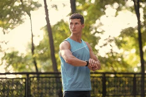 Premium Photo | Man sportsman in activewear checking time on smartwatch