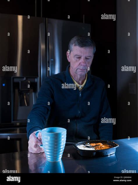Lonely senior man eating ready meal at table Stock Photo - Alamy