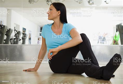 Woman Doing A Lower Back Stretching Exercise Stock Photo - Download Image Now - 25-29 Years ...