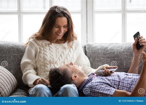 Happy Smiling Couple Relaxing on Sofa Talking Laughing Holding Stock Photo - Image of cellphone ...
