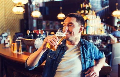 happy man drinking beer at bar or pub | Stock image | Colourbox