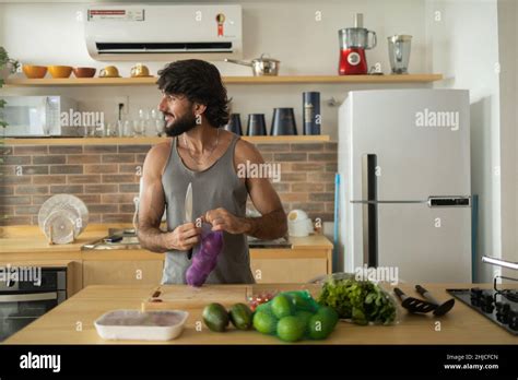 Happy and healthy young man meal prepping whole vegetarian meal in the ...