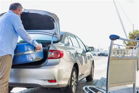 Portrait of Mature Businessman Putting His Luggage on Car Trunk with ...