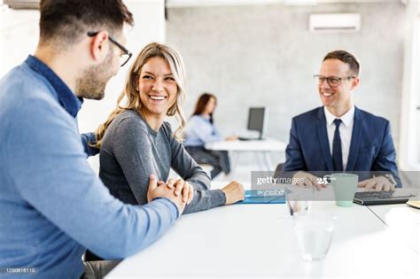 Young happy couple communicating while having a meeting with their ...