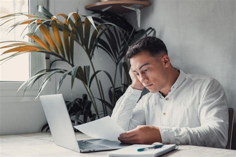 Premium Photo | Confused frustrated young man reading letter debt ...