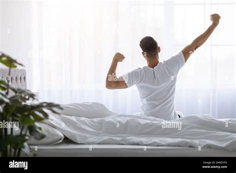Man Stretching In Bed After Waking Up In The Morning, Rear View Stock ...