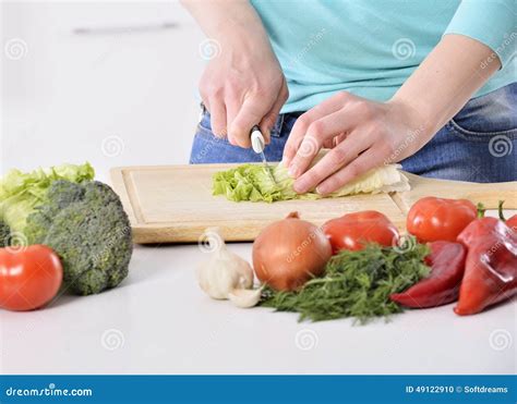 Woman Cooking In New Kitchen Making Healthy Food With Vegetables. Stock Photo - Image: 49122910