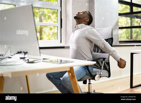 Employee Stretching At Office Desk At Work Stock Photo - Alamy