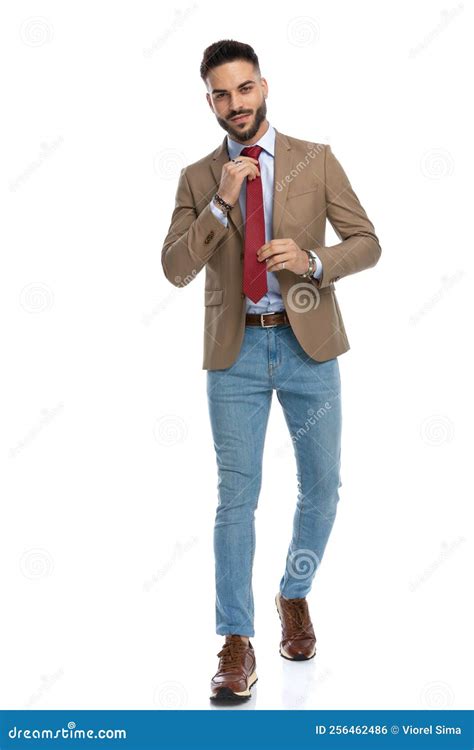 Confident Smart Casual Man Arranging Red Tie while Walking Stock Photo ...
