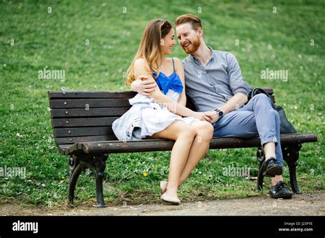 Romantic couple in love sitting on park bench Stock Photo - Alamy