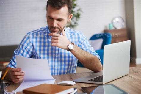 Business person reading important documents at his desk Stock Photo by gpointstudio
