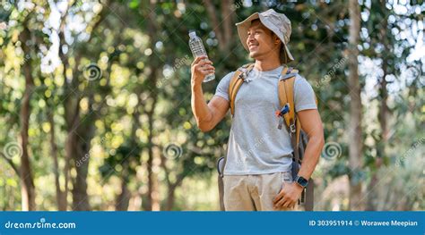 Young Man Backpacker Traveling Alone in Forest. Attractive Male Traveler Drinking Water while ...