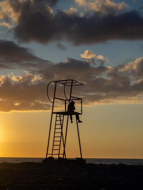 Premium Photo | Guy in a hood on a rescue tower silhouette of a young lonely man silhouette of a ...
