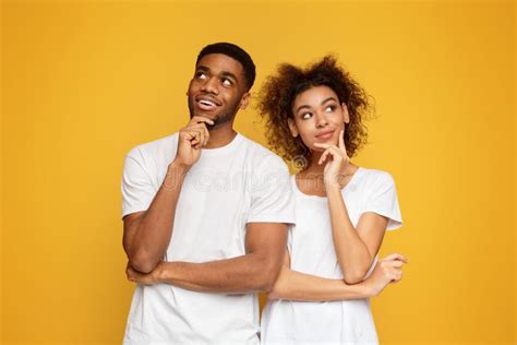Young Couple Day Dreaming on Orange Background Stock Image - Image of ...
