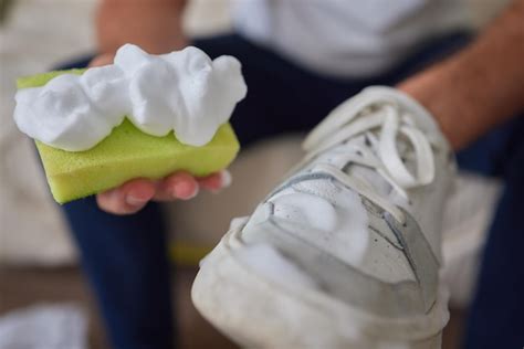 Premium Photo | Cleaning suede sneakers a worker in a shoe workshop ...