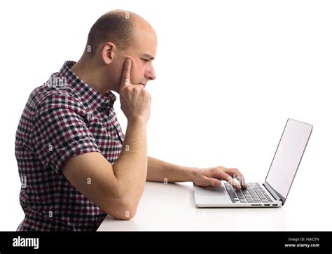 thoughtful man working on his laptop computer. Side view Stock Photo ...