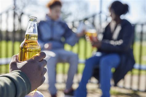 Close Up Of Underage Teenagers Drinking Alcohol In Park | Renna Media