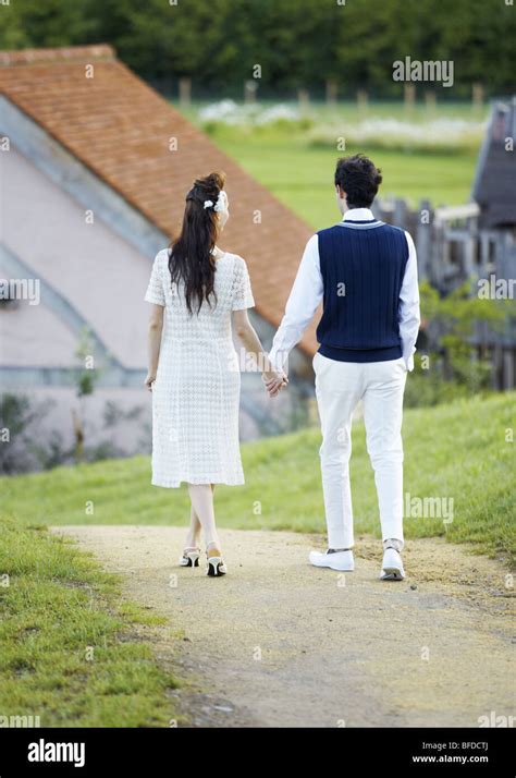 Walking couple holding hands Stock Photo - Alamy