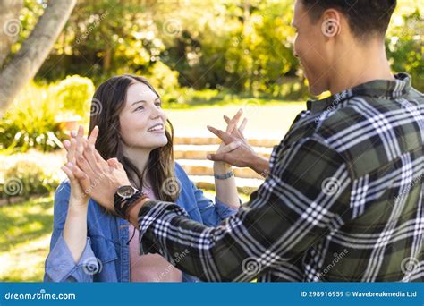 Happy Diverse Couple Holding Hands and Looking at Each Other in Sunny ...