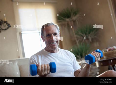 Older man lifting weights at home Stock Photo - Alamy
