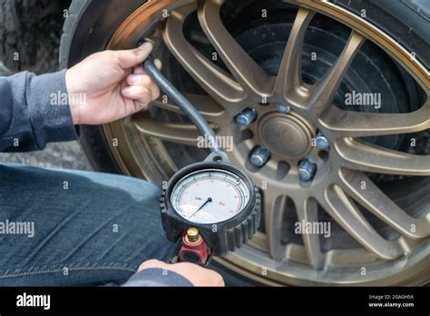 Tire Pressure Gauge and technician hands checking tyre pressure Stock Photo - Alamy