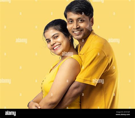 Indian young couple in yellow dress smiling and looking at camera on ...