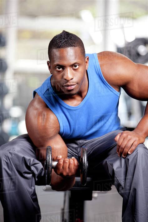 Young muscular black man lifting weights in a gym - Stock Photo - Dissolve