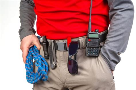 Premium Photo | Pen knife and flashlight with clips on the waistband of ...