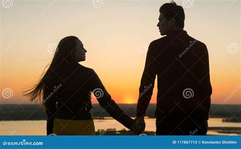 Loving Young Couple Holding Hands Looking Each Other at Amazing Sunset ...